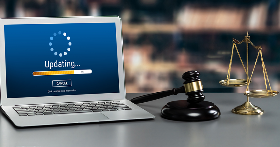 Laptop mit Software-Update, Richterhammer und Justizwaage als Symbol für rechtliche Software-Updates, Compliance und Digitalisierung im Rechtswesen